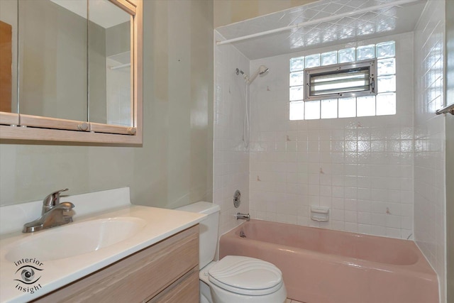 full bathroom featuring tiled shower / bath, vanity, and toilet