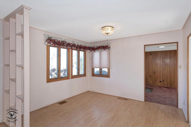 empty room featuring light hardwood / wood-style flooring and ornamental molding