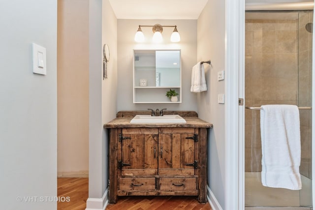 bathroom with vanity, hardwood / wood-style flooring, and a shower with door