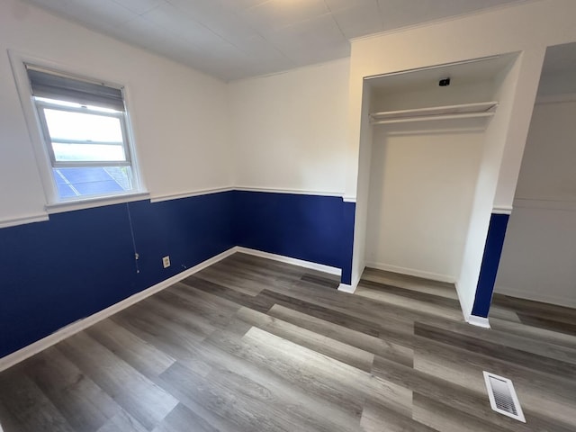 unfurnished bedroom with hardwood / wood-style floors and a closet