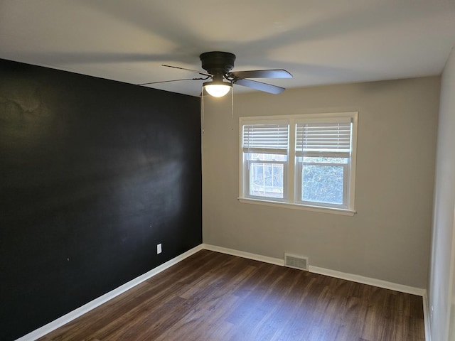 spare room with dark wood-type flooring and ceiling fan