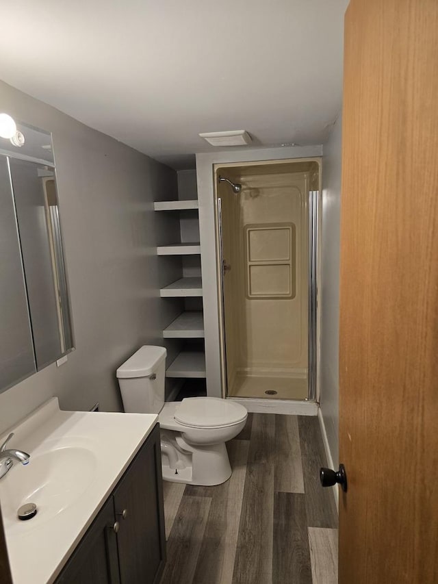 bathroom with walk in shower, vanity, toilet, and hardwood / wood-style floors