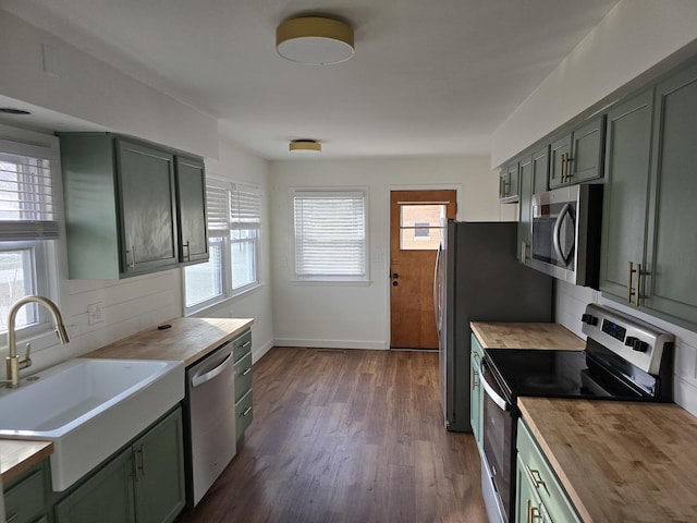 kitchen featuring butcher block counters, stainless steel appliances, and green cabinetry