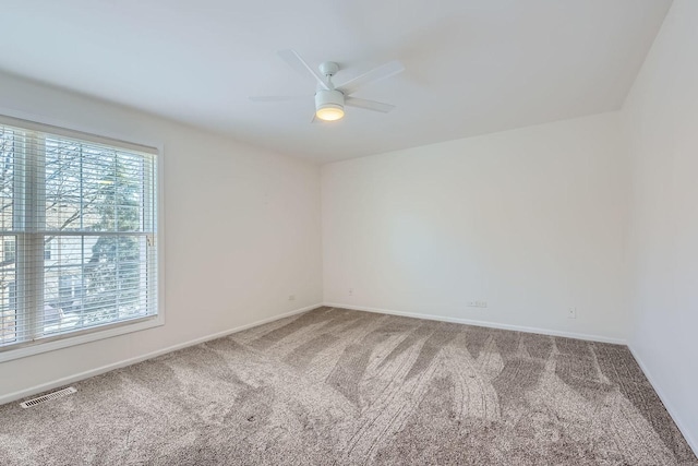 carpeted spare room featuring ceiling fan