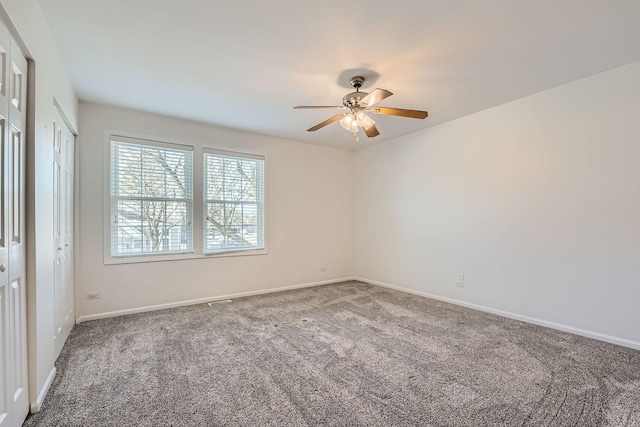 unfurnished room with ceiling fan and carpet