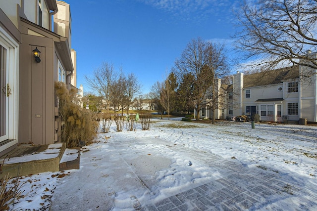 yard layered in snow featuring central AC