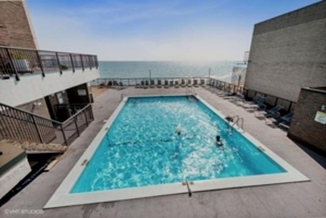 view of swimming pool with a patio area and a water view