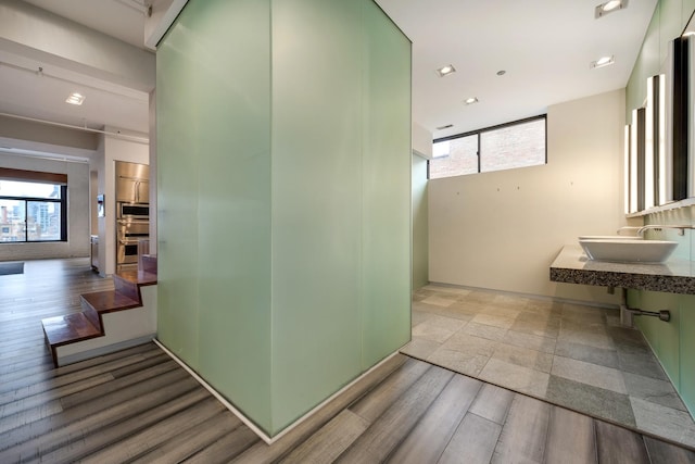 hallway with sink and light wood-type flooring