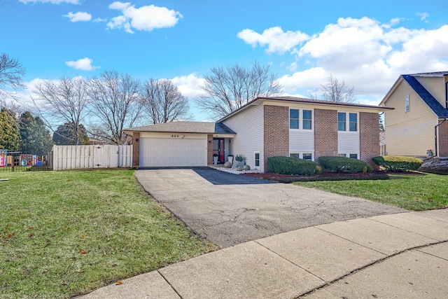 view of front of property featuring driveway, a front lawn, fence, an attached garage, and brick siding