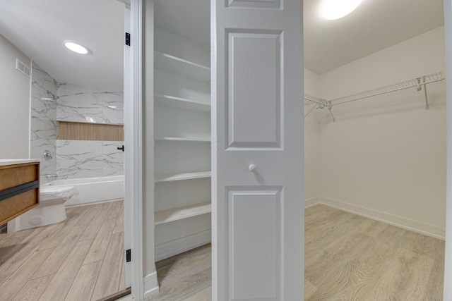 spacious closet with light hardwood / wood-style flooring