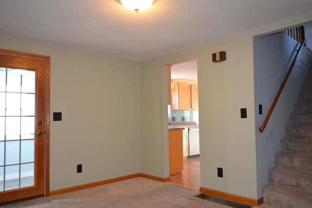 carpeted empty room featuring a textured ceiling