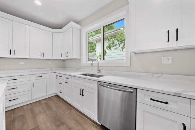 kitchen with dishwasher, white cabinetry, sink, hardwood / wood-style flooring, and light stone counters