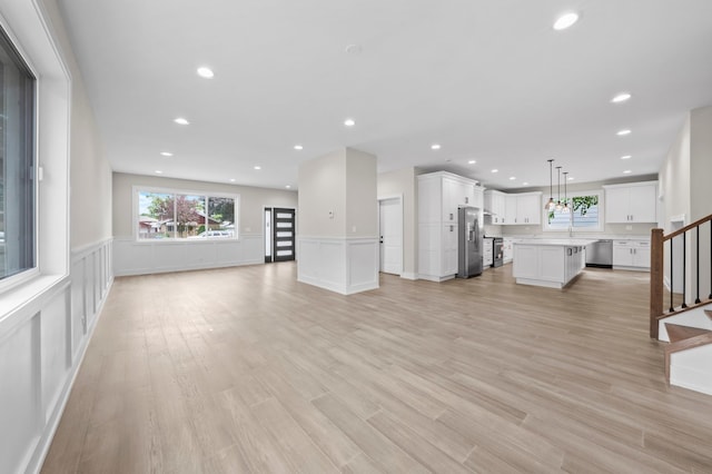 unfurnished living room with sink and light wood-type flooring