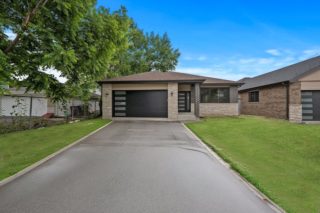 view of front facade featuring a garage, a front lawn, and a sunroom