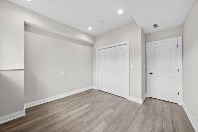 unfurnished bedroom with a closet and light hardwood / wood-style flooring