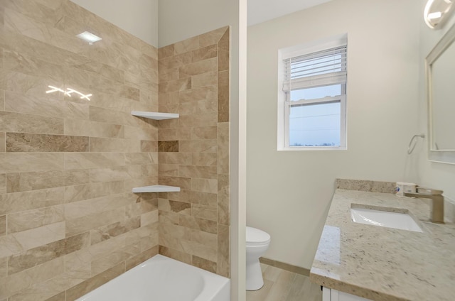 full bathroom featuring toilet, tiled shower / bath combo, and vanity