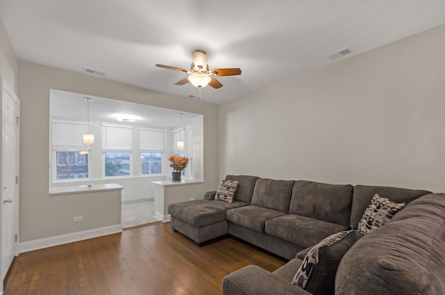 living room featuring ceiling fan and dark hardwood / wood-style flooring