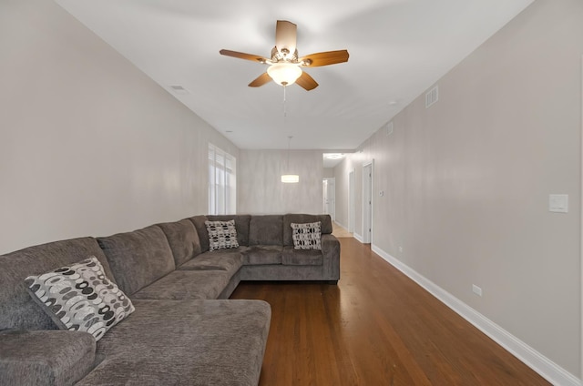 living room with ceiling fan and dark hardwood / wood-style flooring