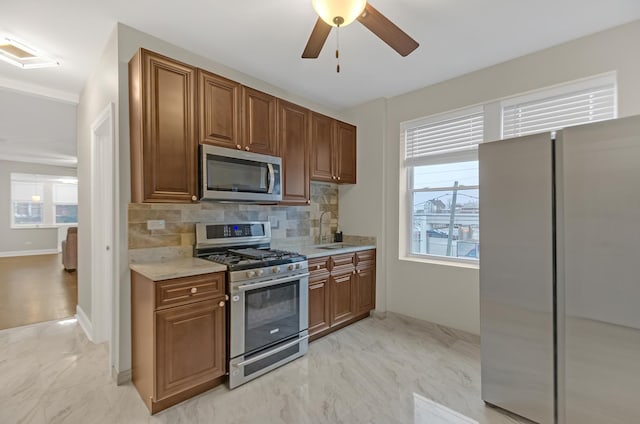 kitchen with decorative backsplash, plenty of natural light, sink, and stainless steel appliances