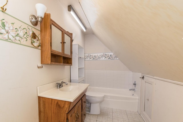 bathroom featuring toilet, a tub to relax in, vaulted ceiling, and vanity