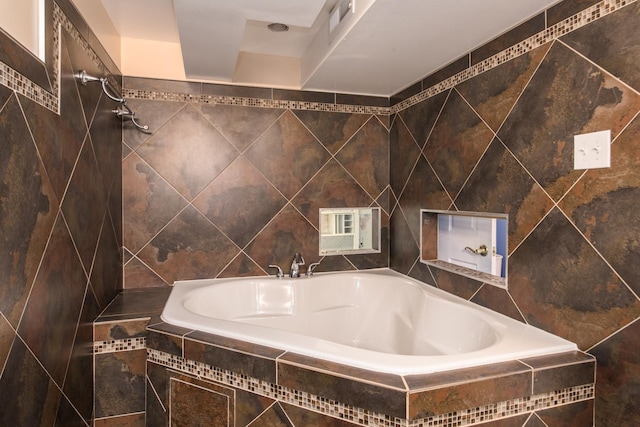 bathroom with tiled bath and tile walls