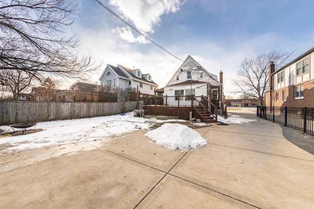 snow covered house featuring a wooden deck