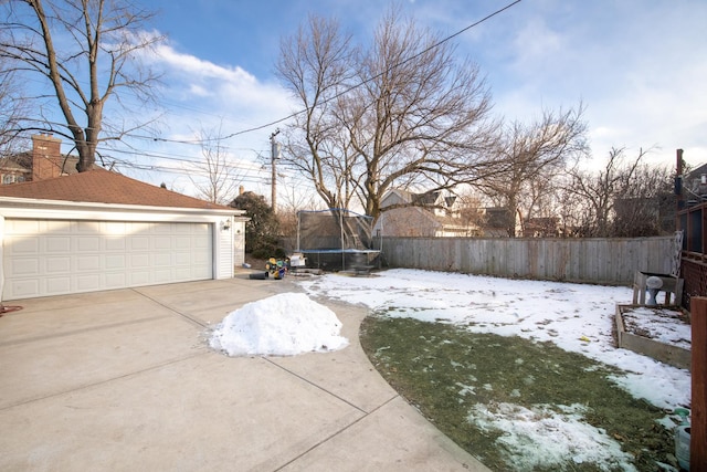 yard covered in snow with a trampoline