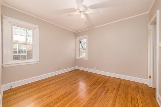 empty room featuring light hardwood / wood-style floors, ornamental molding, ceiling fan, and a healthy amount of sunlight