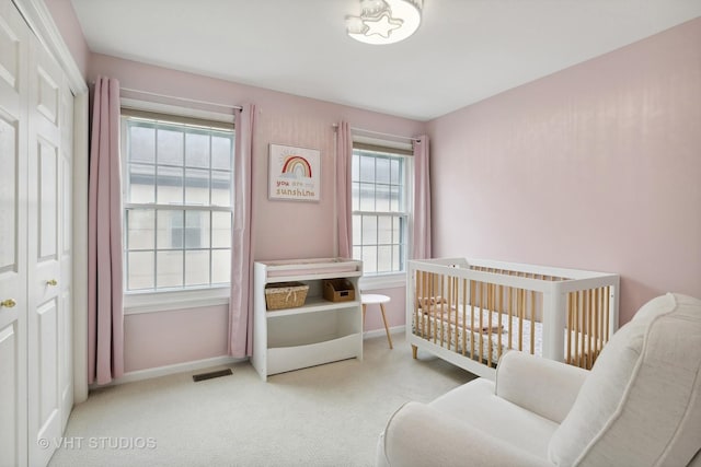 bedroom featuring light colored carpet and a crib