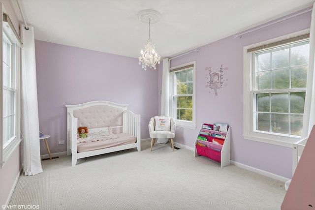 carpeted bedroom with a notable chandelier