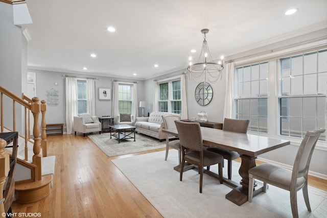 dining room with ornamental molding, a chandelier, and light hardwood / wood-style floors