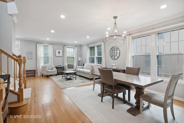 dining area with an inviting chandelier, ornamental molding, and light wood-type flooring