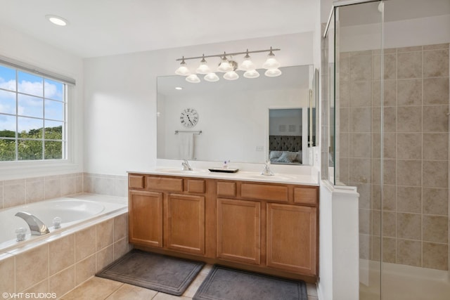 bathroom with independent shower and bath, vanity, and tile patterned flooring