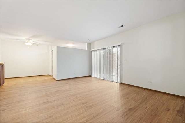 spare room featuring visible vents, ceiling fan, light wood-style flooring, and baseboards