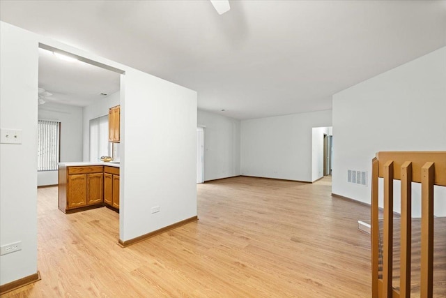 unfurnished room featuring light wood-type flooring, baseboards, and visible vents