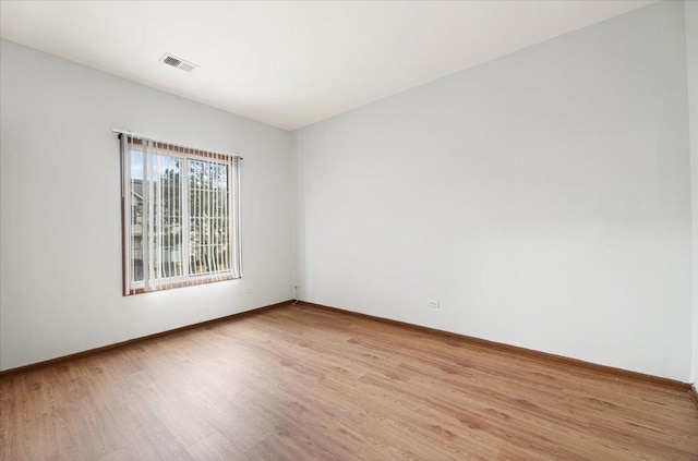 unfurnished room with baseboards, visible vents, and light wood finished floors