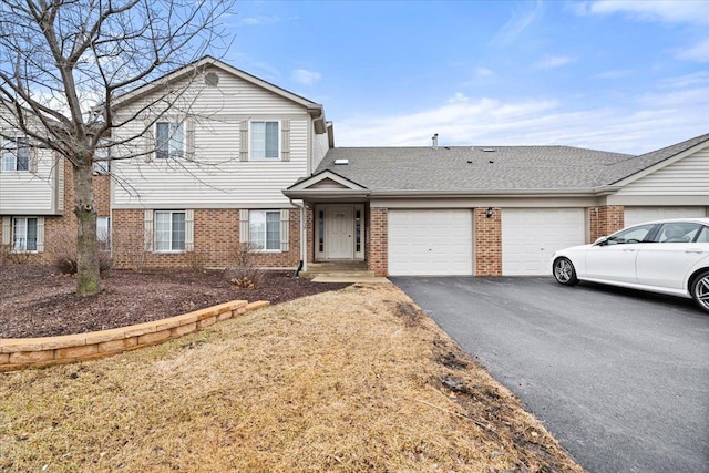 view of front of house featuring a garage, driveway, brick siding, and a shingled roof