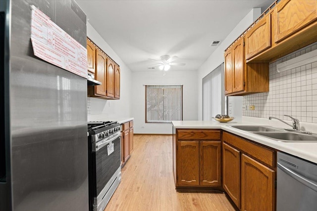 kitchen featuring visible vents, stainless steel appliances, light countertops, light wood-style floors, and a sink