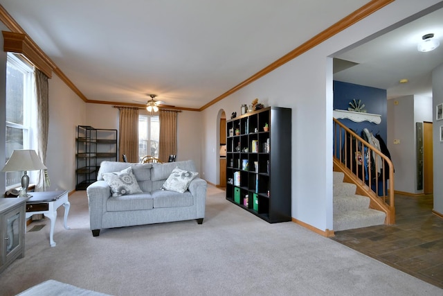 living room with ornamental molding, carpet floors, and ceiling fan