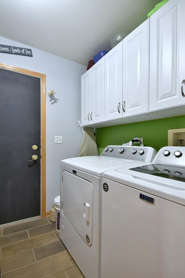 clothes washing area featuring cabinets and washing machine and clothes dryer