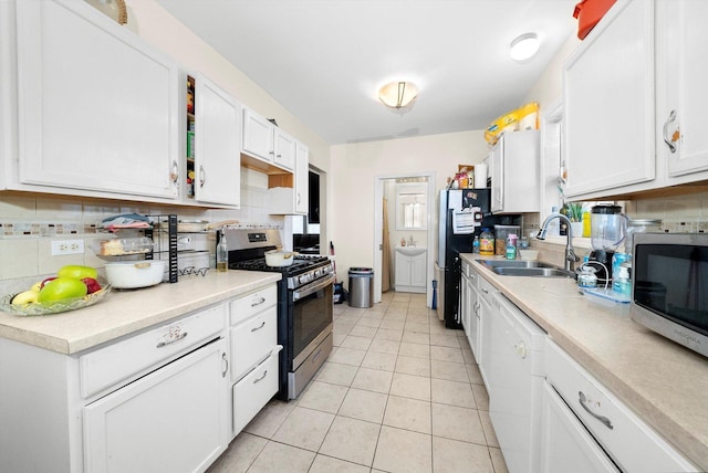 kitchen featuring light tile patterned floors, appliances with stainless steel finishes, sink, and white cabinetry