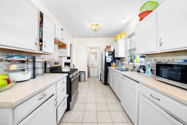 kitchen featuring light tile patterned floors, appliances with stainless steel finishes, white cabinets, and sink