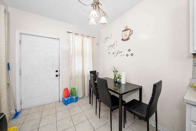 tiled dining room with a notable chandelier