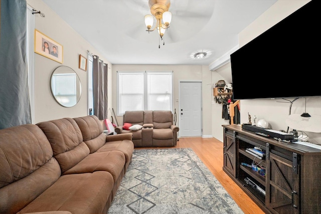 living room featuring ceiling fan, light hardwood / wood-style flooring, and lofted ceiling