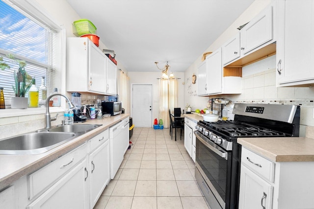 kitchen featuring backsplash, sink, light tile patterned flooring, white cabinetry, and appliances with stainless steel finishes