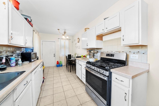 kitchen with light tile patterned flooring, appliances with stainless steel finishes, white cabinetry, and a notable chandelier