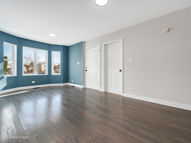 unfurnished room with dark hardwood / wood-style floors