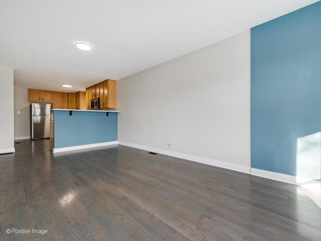 unfurnished living room featuring dark hardwood / wood-style flooring