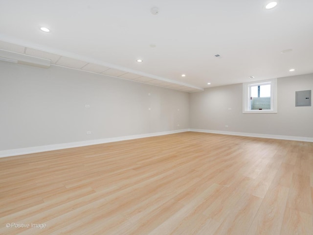 empty room featuring light wood-type flooring and electric panel