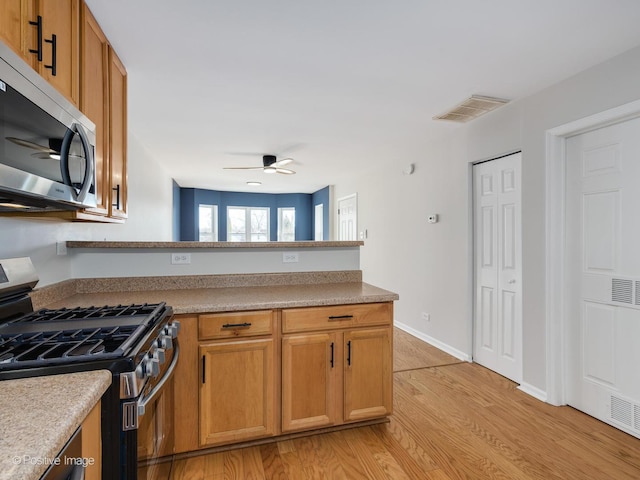 kitchen featuring light hardwood / wood-style floors, appliances with stainless steel finishes, and ceiling fan